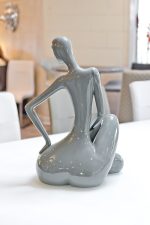 ceramic grey sitting lady in our showroom from the back